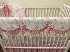 a baby crib with pink and white bedding on the bottom, along with matching ruffles