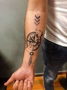 a man with a compass tattoo on his arm