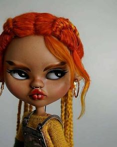 an orange haired doll with long braids and piercings on it's nose