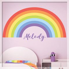 a child's bedroom with a rainbow wall decal