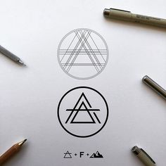 some pens and pencils on top of a piece of paper with an image of a triangle in the middle