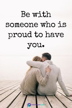 a man and woman sitting on top of a wooden dock next to the ocean with a quote about love