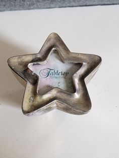 a silver star shaped object sitting on top of a table