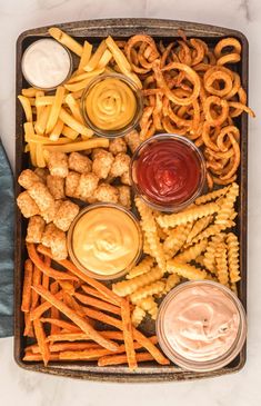 a tray filled with different types of food and dips on top of each other