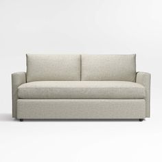 a white couch sitting on top of a white floor next to a wall with a light colored background