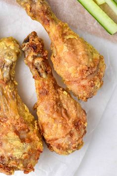 three fried chicken wings with celery sticks in the background