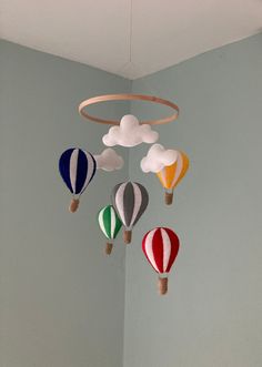 several hot air balloons hanging from the ceiling in a child's room with blue walls