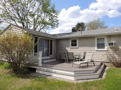 a house with a deck and patio in the front yard