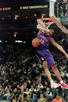 a basketball player dunking the ball in front of an audience