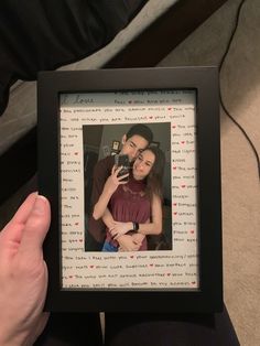 a man and woman are holding up a polaroid with hearts on the frame in front of them