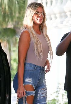 a blonde woman in ripped jeans and heels