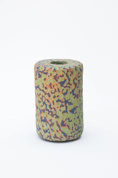 a roll of toilet paper that is green and blue with multicolored spots on it