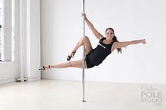 a woman is doing pole dancing in an empty room