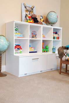 a white bookcase filled with lots of toys