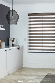 the blinds in this kitchen are made from shades of brown and white, with grey walls