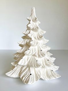 a white ceramic christmas tree sitting on top of a table