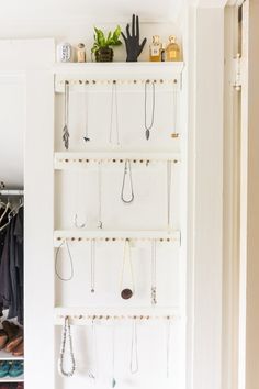 an organized closet with lots of hanging items on the shelves and hooks in front of it