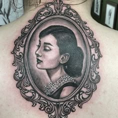 a woman's back with an ornate frame around her neck and the image of a woman in profile