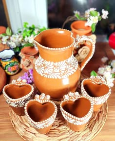 a table topped with vases and pots filled with flowers on top of a wooden table