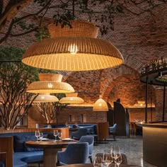 a restaurant with tables, chairs and lights hanging from the ceiling over it's dining area