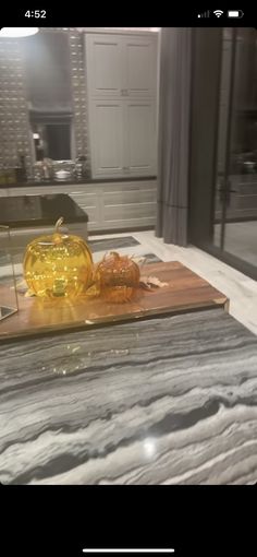 a yellow glass vase sitting on top of a wooden cutting board