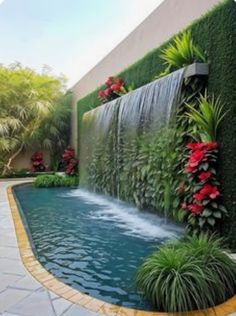 an outdoor pool with waterfall surrounded by greenery and red poinsettia plants