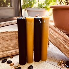 three black and yellow candles sitting next to each other