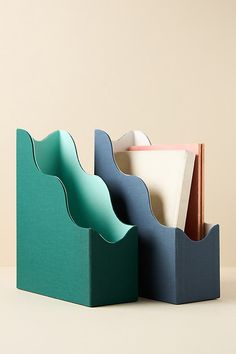 three different colored paper holders sitting next to each other