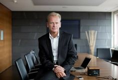 a man in a suit sitting at a conference table