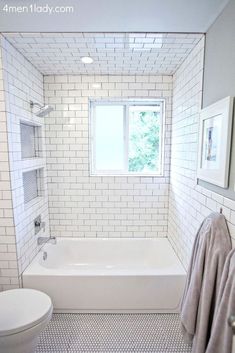 a bathroom with white and gray tiles on the walls