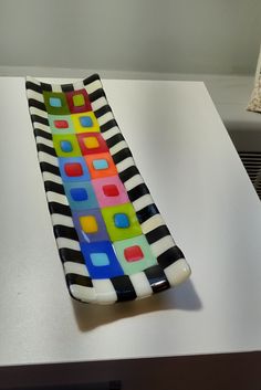 a multicolored glass vase sitting on top of a table