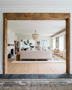 an open living room with white furniture and wood floors