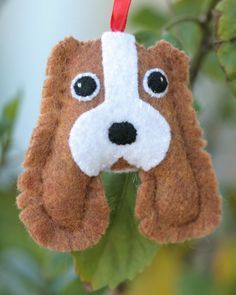 a brown and white dog ornament hanging from a tree