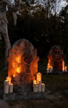 candles are lit in front of a grave