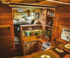 the interior of a tiny home with wood paneling and wooden cabinets, including a stove top oven