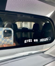 a person taking a selfie in the side mirror of a car with their cell phone