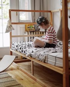 a young boy sitting on top of a bed