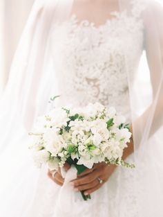 a woman in a wedding dress holding a bouquet of flowers