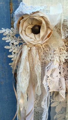 an old lace curtain with a flower on it's side and ribbon around the edge