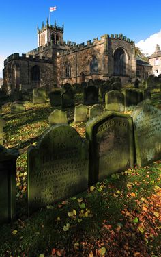 an old cemetery with many headstones in front of it and a building behind it