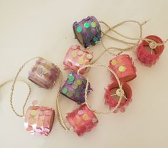 some pink and green decorations are tied up on a white table with twine around them