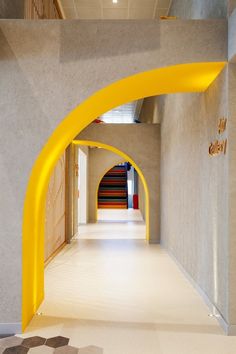 the entrance to an art gallery with yellow arches and geometric patterns on the flooring