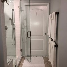 a walk in shower sitting next to a white door