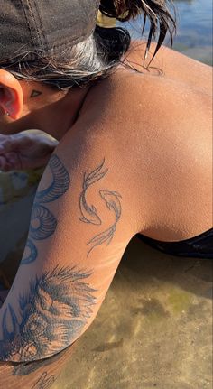 the back of a woman's body with tattoos on it