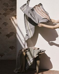 a woman's dress is hanging up against a wall with her hands in the air