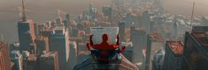 a spider man sitting on top of a tall building in the middle of a city