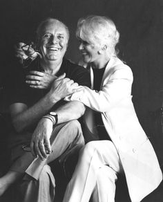 an old photo of two people sitting on top of each other, one man is holding the woman's arm