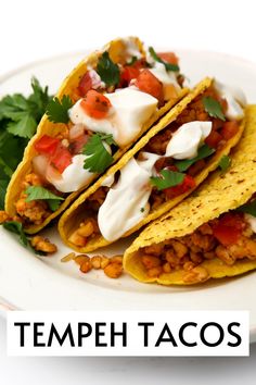 three tacos on a white plate with the words tempeh tacos