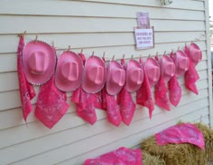 pink hats are hung on the side of a house