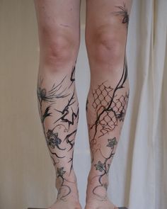 the legs and ankles of a woman with tattoos on her body, standing on a suitcase